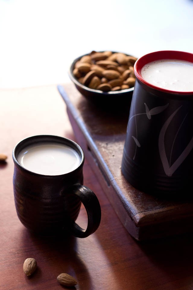 almond milk in a black ceramic jar and small mug.