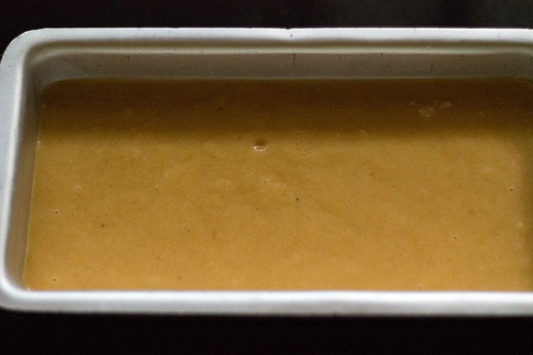 leveled orange cake batter in baking tin