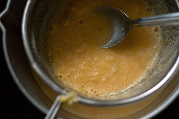 straining fresh orange juice 