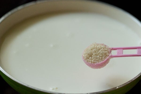 sugar being added to warmed milk