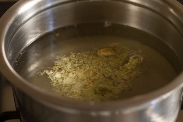 ginger, hot water and crushed cardamom in a saucepan