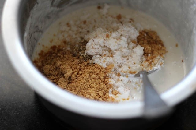 adding jaggery, grated coconut, salt and cardamom powder in idli batter