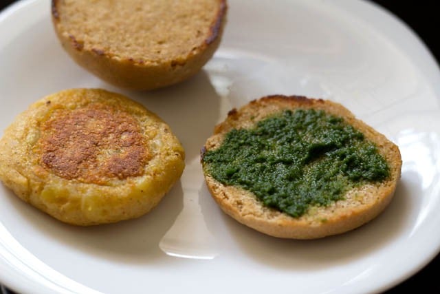 apply coriander chutney to one half of the burger bun.