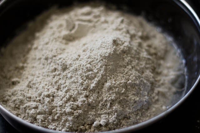 bajra flour added to bowl with water.