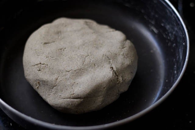 dough has been gathered and kneaded for making the bajra roti recipe - it looks relatively smooth in a ball, with a few cracks.