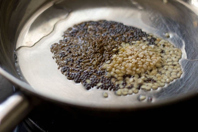 mustard, cumin and urad dal in a pan with oil.