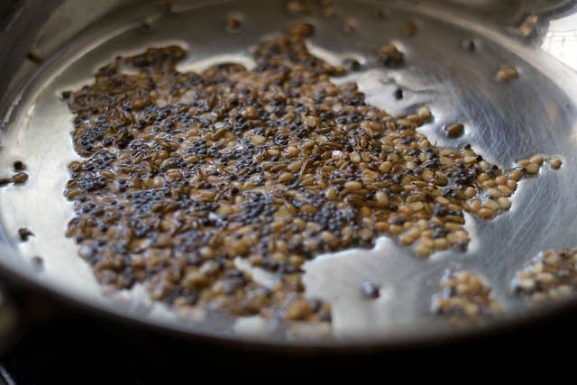frying mustard, cumin and urad dal in a pan
