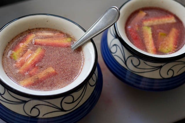 steel spoon inside one ceramic jar filled with water, carrots and spices