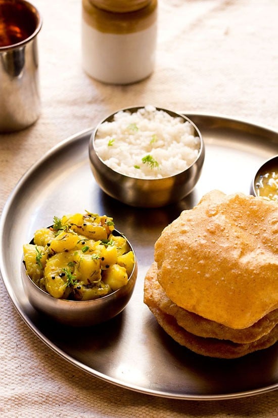 poori bhaji recipe on a thali with fresh puri and steamed rice.