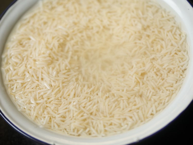 rice grains being soaked to make pulao recipe.