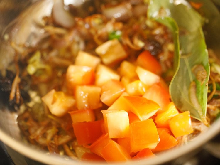 adding tomatoes to the pulao.