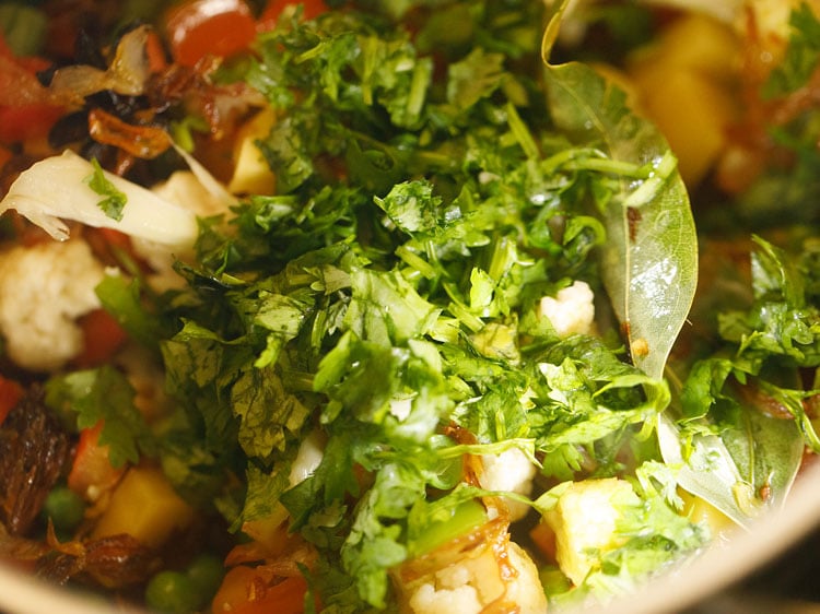 adding coriander (cilantro) in pan to make veg pulav.