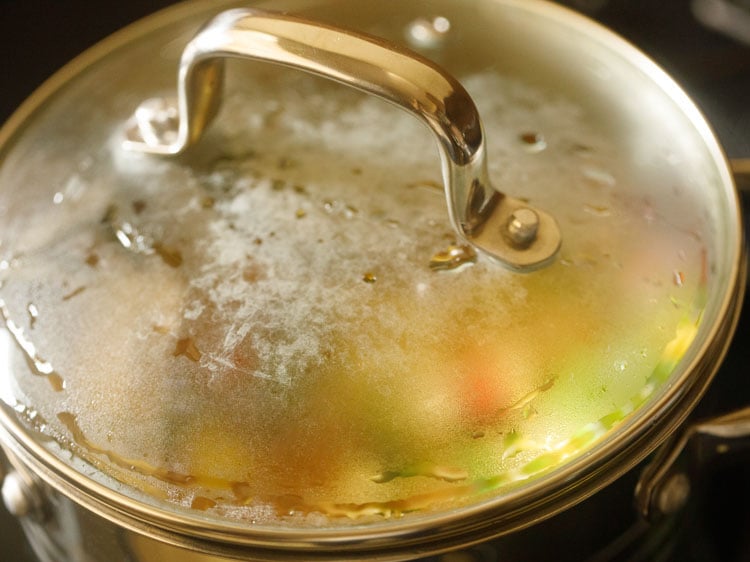 covering the pan with lid and cooking rice for pulao