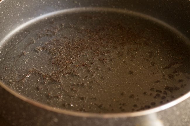 mustard seeds in a pan with oil