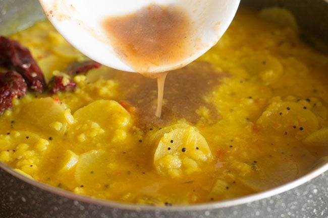 adding tamarind pulp and sambar powder to pan