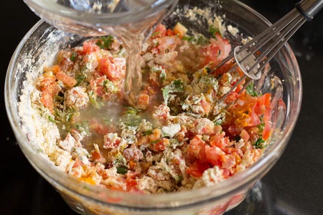 water being poured on omelette ingredients in bowl