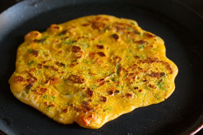 veg omelette turned over and second side being cooked on skillet