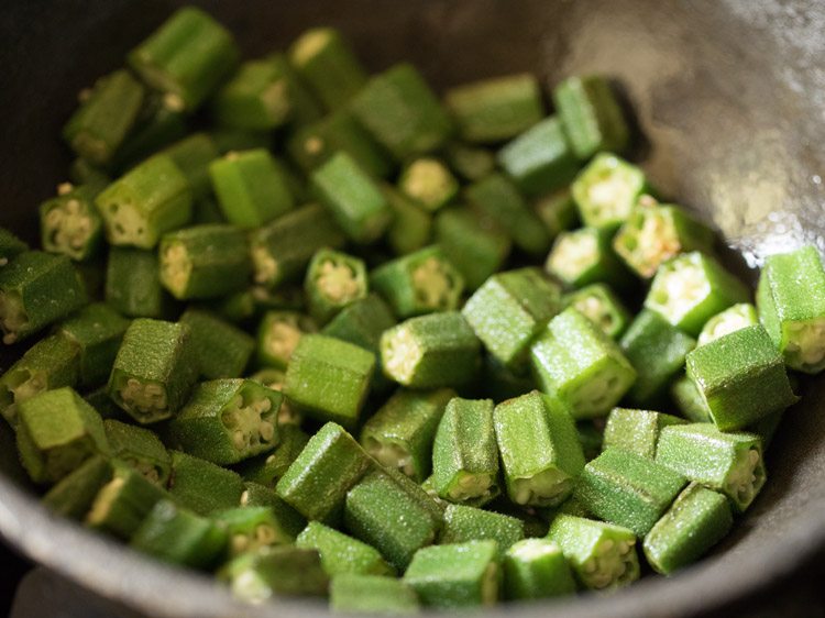 sautéing okra for making bhindi masala recipe. 