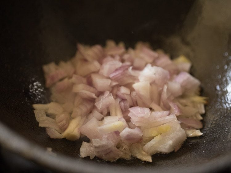 chopped onions added to hot oil in heavy pan for making bhindi masala recipe. 