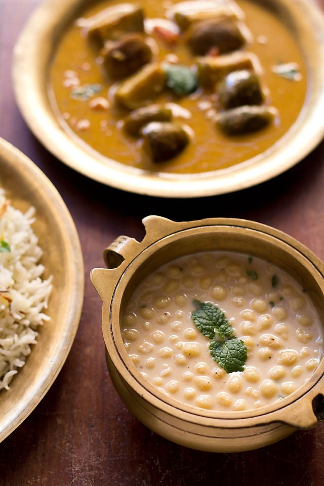 boondi raita served in a bowl with a side of rice and brinjal curry.