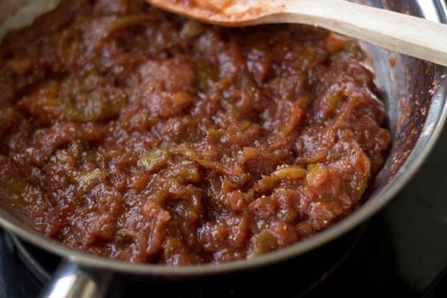 adding ground cinnamon powder and lemon juice to cooked fig jam in pan