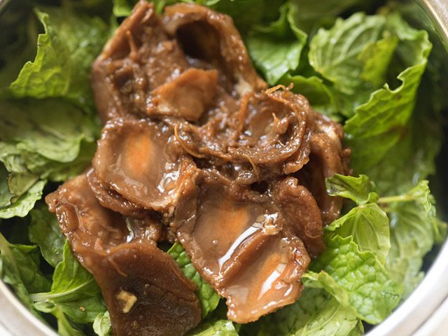 adding soaked tamarind to mint leaves in grinder jar 