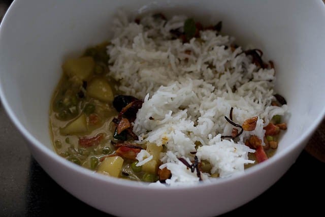 layering of cooked vegetable gravy and rice in ovenproof bowl 