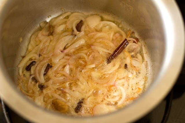frying remaining sliced onions with spices for kerala biryani 
