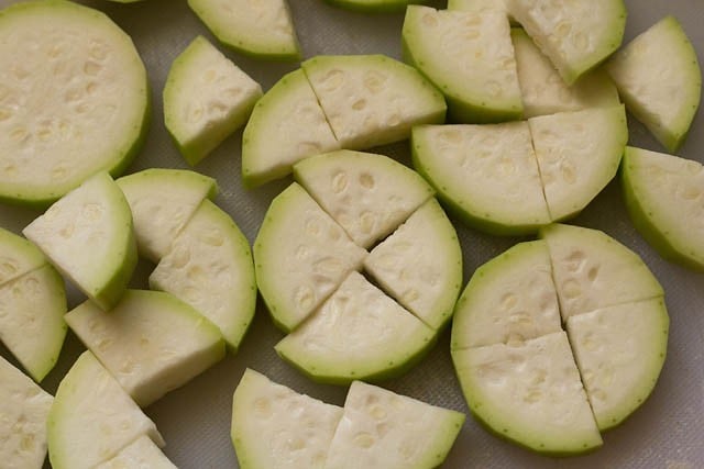 chopping lauki or bottle gourd into small pieces 