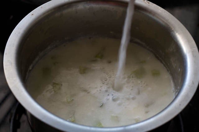 adding coconut milk to lauki curry