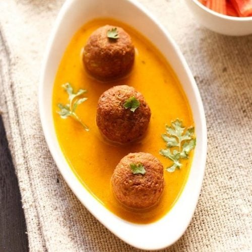 lauki kofta garnished with coriander leaves and served in a white dish.