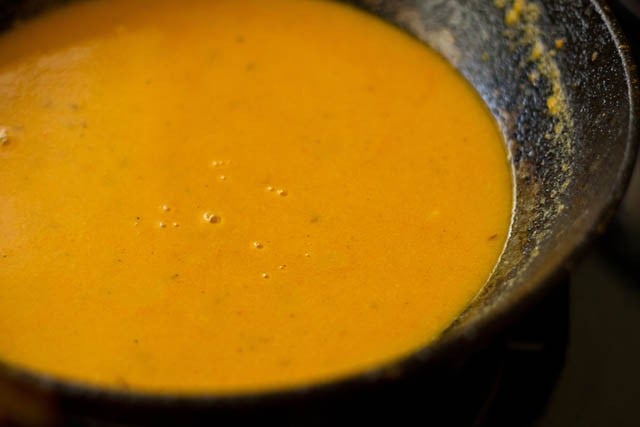 adding strained lauki juice and water to masala paste, simmering the curry to make lauki ke kofte.  