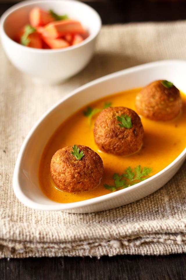 lauki kofta served in a serving bowl with carrot batons in a bowl 