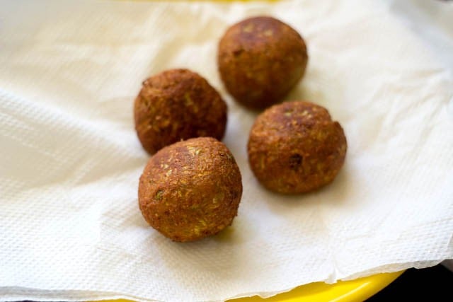 draining fried lauki ke kofte on paper towels. 