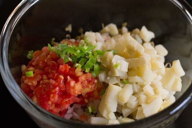 finely chopped tomatoes, green chilies and boiled potato in bowl 