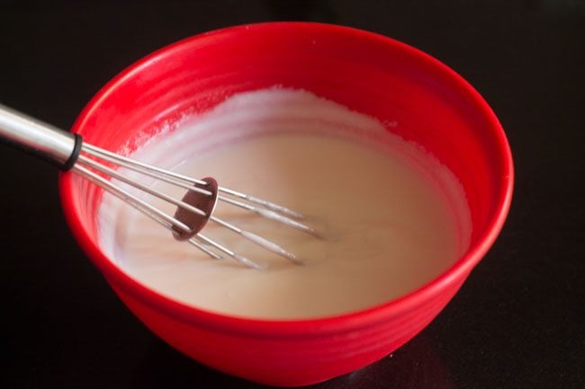 whisking curd for palak raita. 