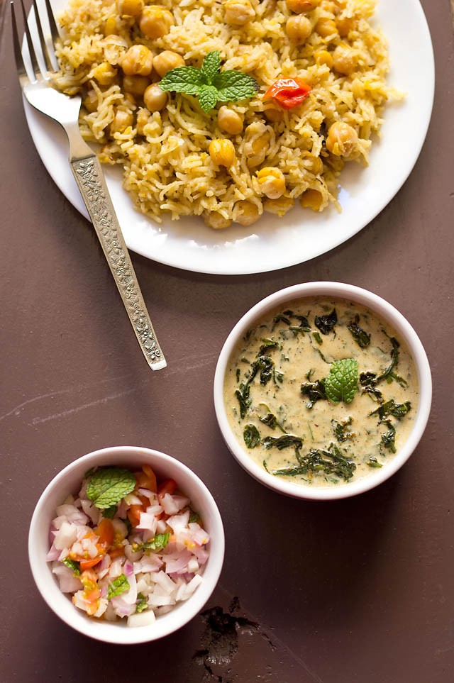 palak raita served alongside with chana pulao and kachumber.