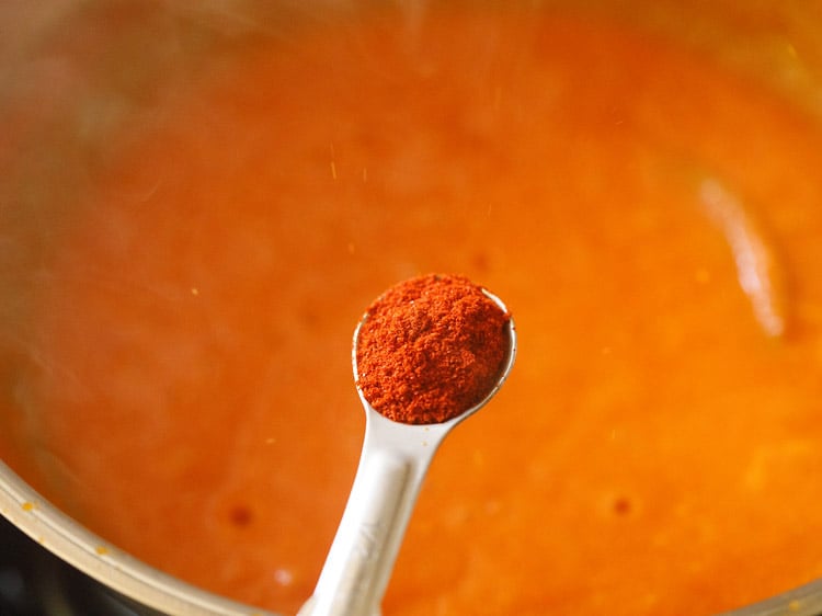 kashmiri red chilli powder being added