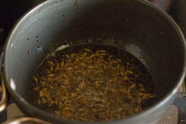 frying cumin seeds in hot oil for tempering 