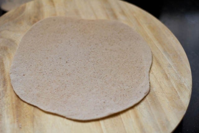 rolled sugar paratha on a rolling board