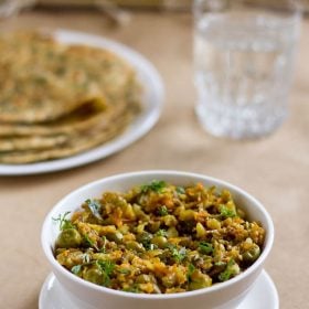 veg keema served in a bowl with parathas and a glass of water