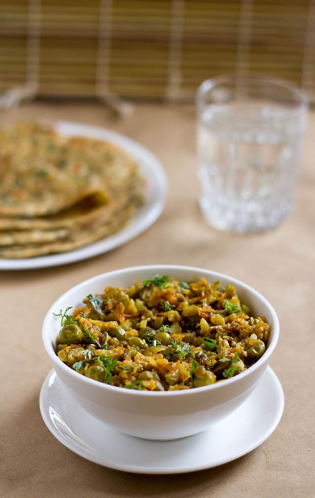 veg keema served in a bowl with parathas and a glass of water