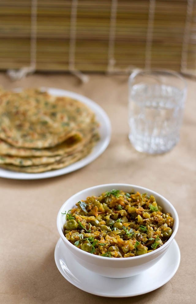 keema de verduras servido en un bol con parathas y un vaso de agua