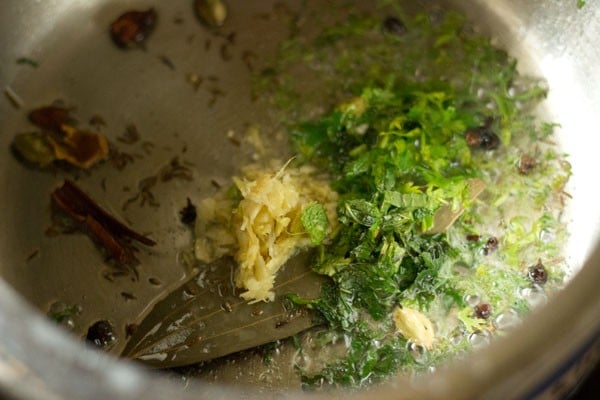 adding ginger-garlic paste, chopped coriander and chopped mint in pressure cooker 