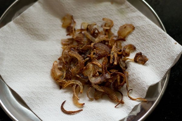 draining fried onions on kitchen paper towels