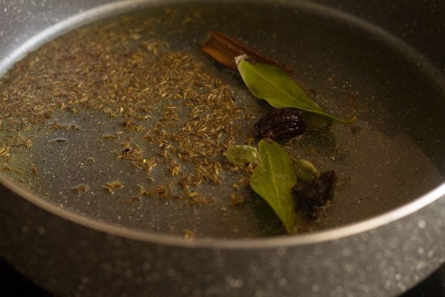 cinnamon stick, caraway seeds, bay leaf, cloves and cardamom pods added to ghee for tadka