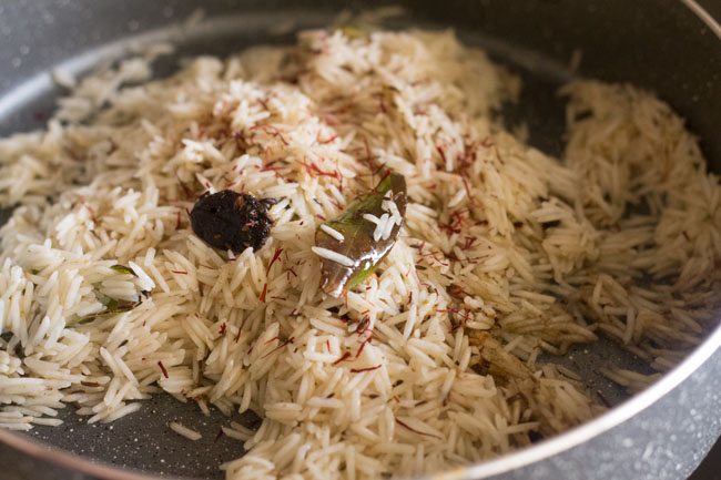 saffron threads added to rice and spiced oil mix