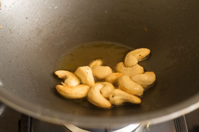 cashews added to pan to fry in oil