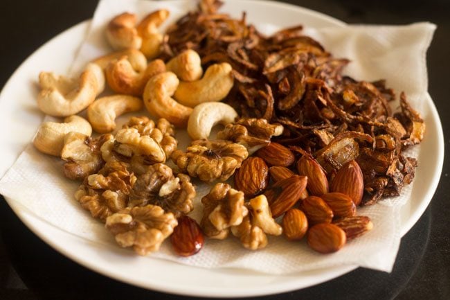 fried walnuts placed on paper towel with other garnishes for kashmiri pulao