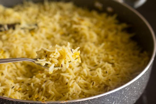 fluffing completed Kashmiri pulao recipe with a fork